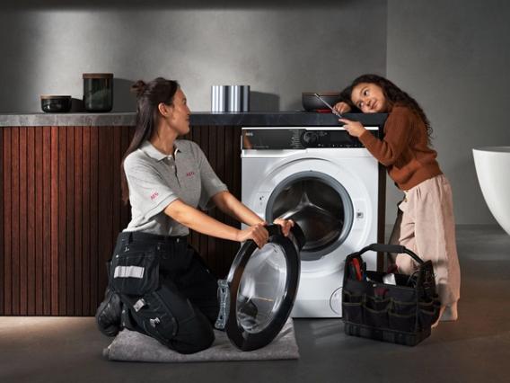 service technician repairing a washing machine AEG