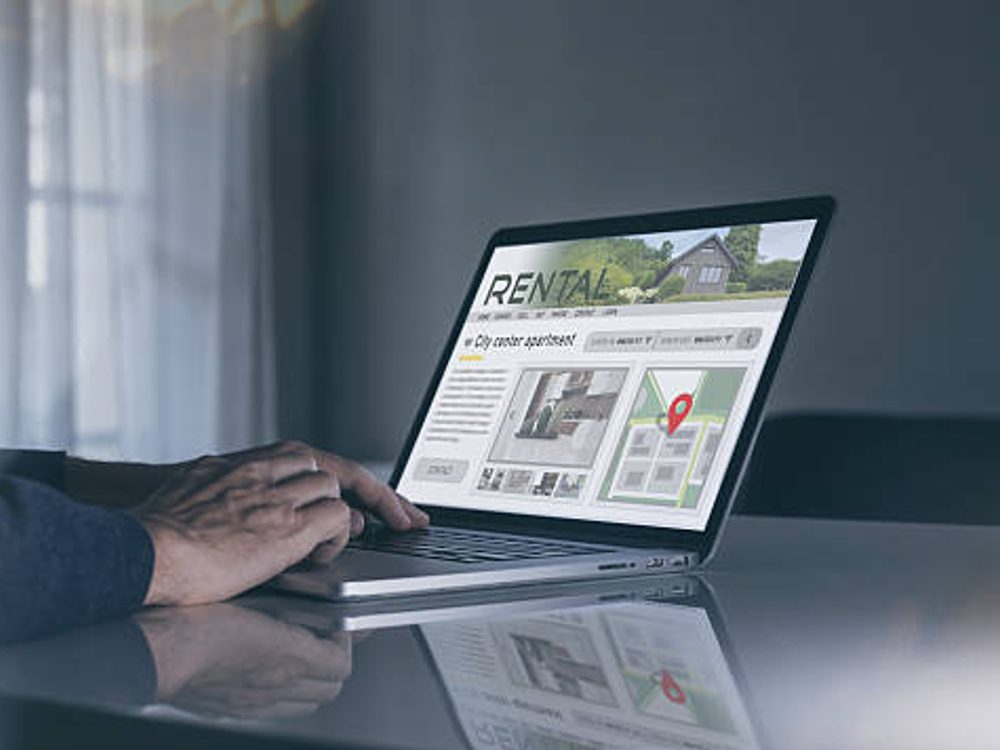 Man looking at a Christchurch property rental website on a laptop
