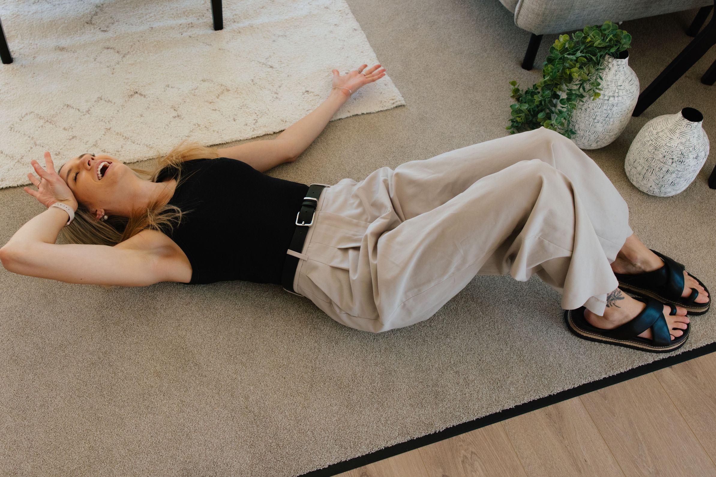 Bex Harris lying on the floor after renting all of the Christchurch based rental properties managed by TED property management