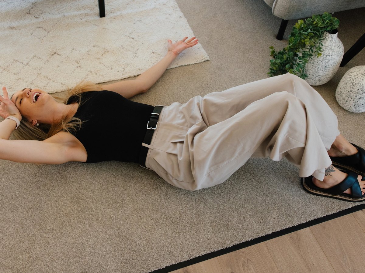 Bex Harris lying on the floor after renting all of the Christchurch based rental properties managed by TED property management
