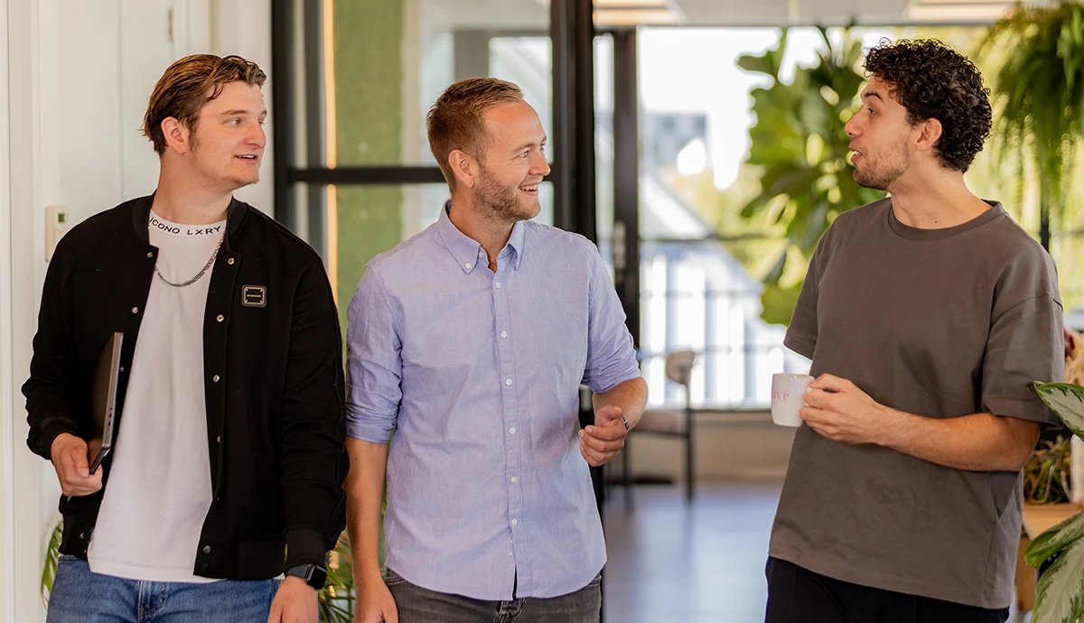 Drie collega’s van Studio MVP in gesprek op kantoor