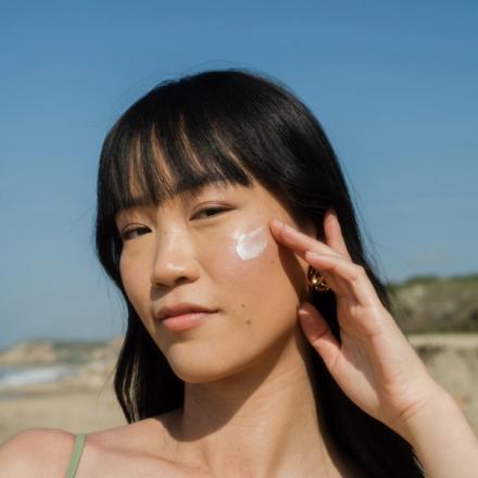 Woman using Coola sunscreen