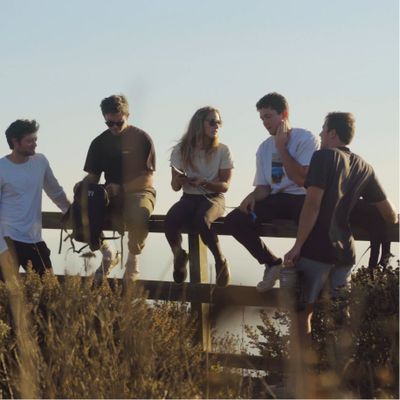 Five people sitting on a wooden fence