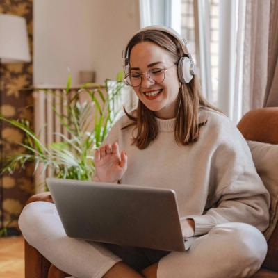 Woman Sitting on Couch Talking to Online Therapist on Computer