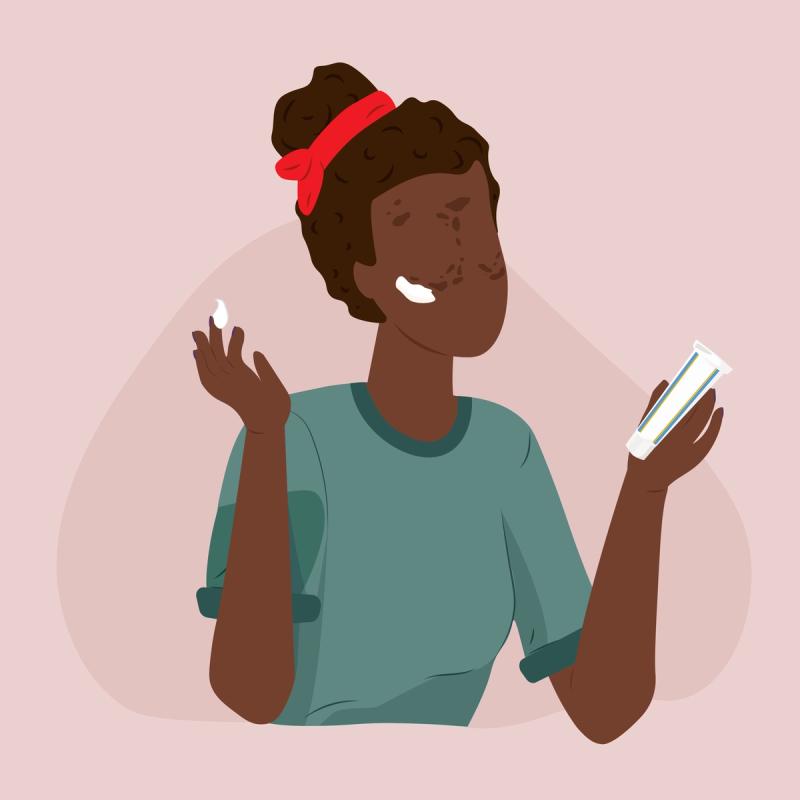 woman applying a dark spot cream to her face