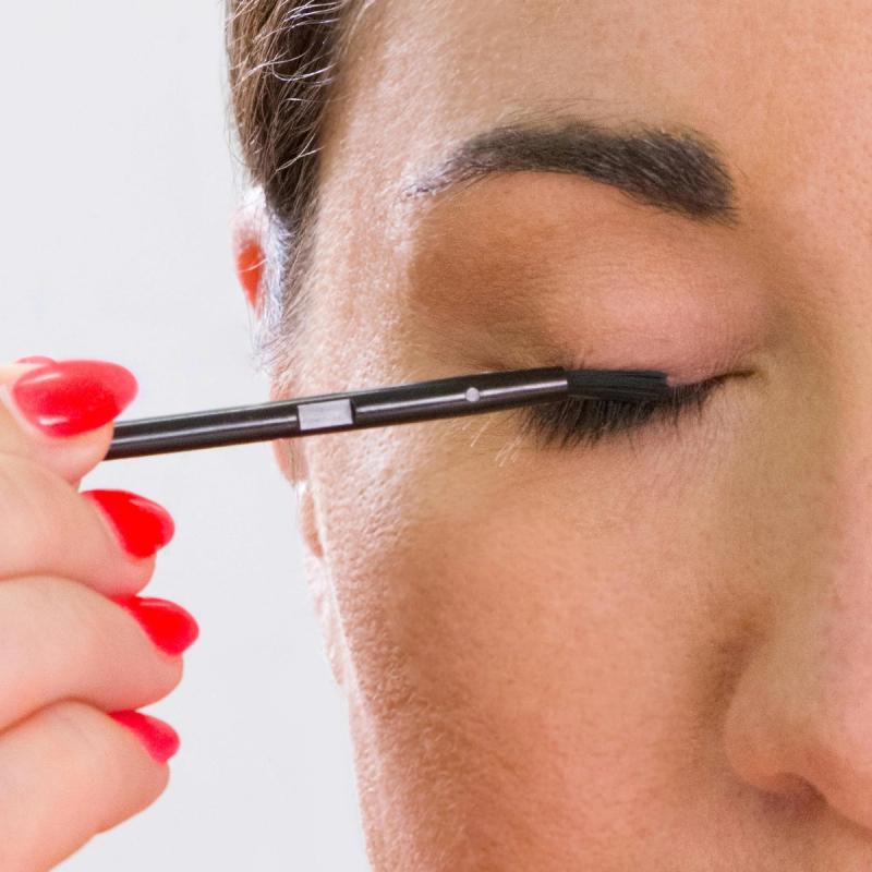 Person applies eyelash growth serum to their eyelashes.
