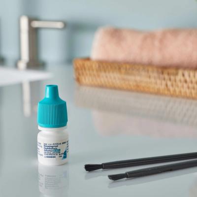 Bimatoprost eyelash serum bottle and applicator on bathroom counter