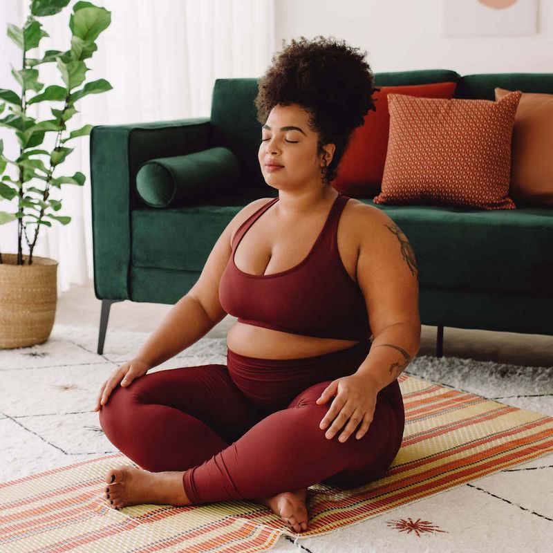 Woman Sitting on Living Room Floor Meditating