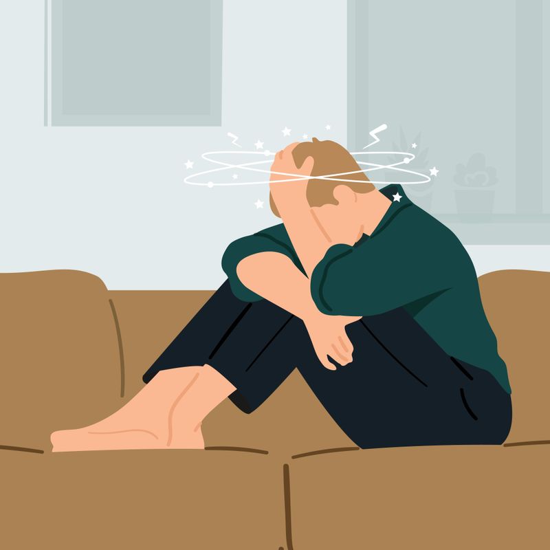 An illustration of a man sitting on a couch with a migraine headache