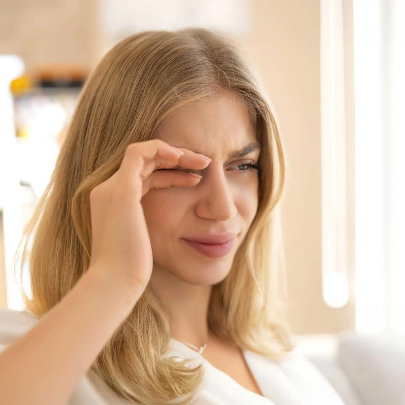 Image of woman scratching her eye due to pink eye.