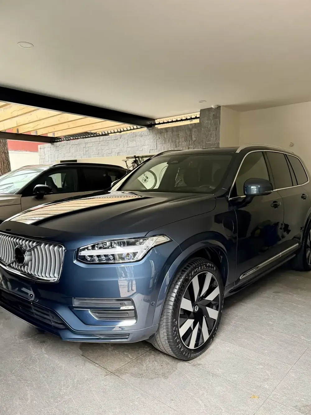 Volvo XC90 azul después del detallado, estacionada en la cochera del cliente
