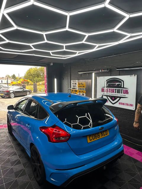 Blue Ford Focus RS with dark-tinted rear windows and rear screen in the MasterTint UK bay, Weston Street, Bolton