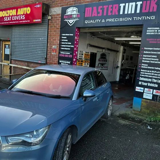 A blue Audi A1 with a chameleon windscreen, outside our bay