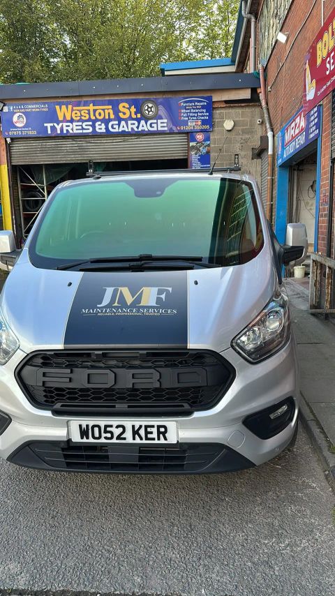 Silver Ford Transit Custom with a green colour-shift windscreen film and black bonnet stripe on Weston Street, Bolton