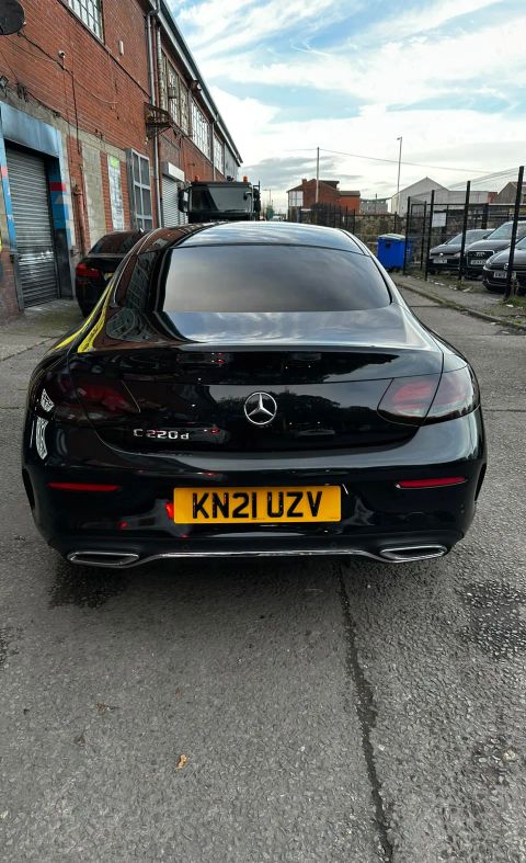 Rear of a black Mercedes C220d Coupe with a dark-tinted rear screen on Weston Street, Bolton