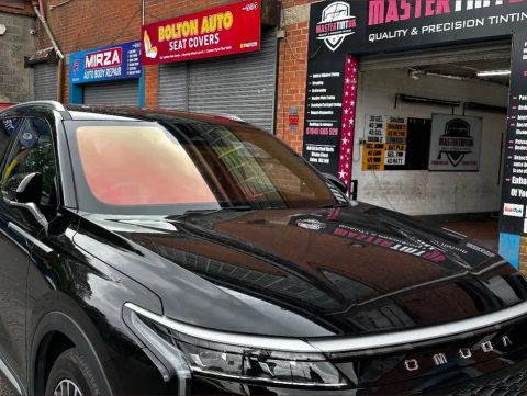 Black Omoda with an orange-pink colour-shift windscreen film outside MasterTint UK, Weston Street, Bolton