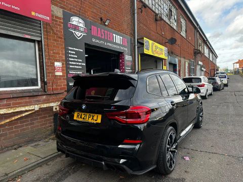 Black BMW X3 M Competition with dark-tinted rear windows and rear screen outside MasterTint UK, Weston Street, Bolton