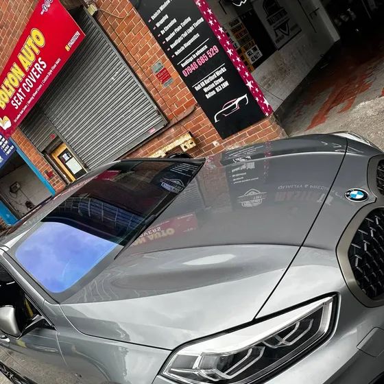 A grey BMW with a chameleon windscreen