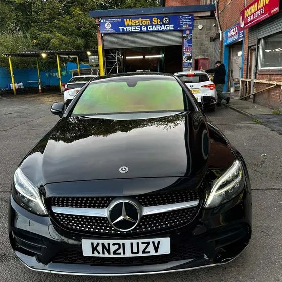A black Mercedes C-Class with a chameleon windscreen, outside our unit