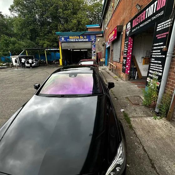 A black coupé with a chameleon windscreen, outside our unit