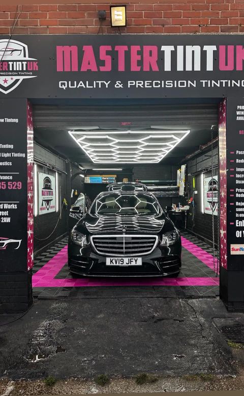 Black Mercedes S400d in the bay at MasterTint UK, Weston Street, Bolton, seen from the street under the shop sign