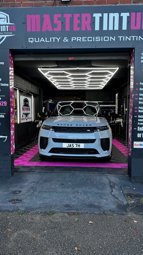 White Range Rover Sport in the bay at MasterTint UK, Weston Street, Bolton, seen from the street under the shop sign