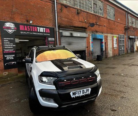 White Ford Ranger pickup with a gold colour-shift windscreen film and black bonnet outside MasterTint UK, Weston Street, Bolton