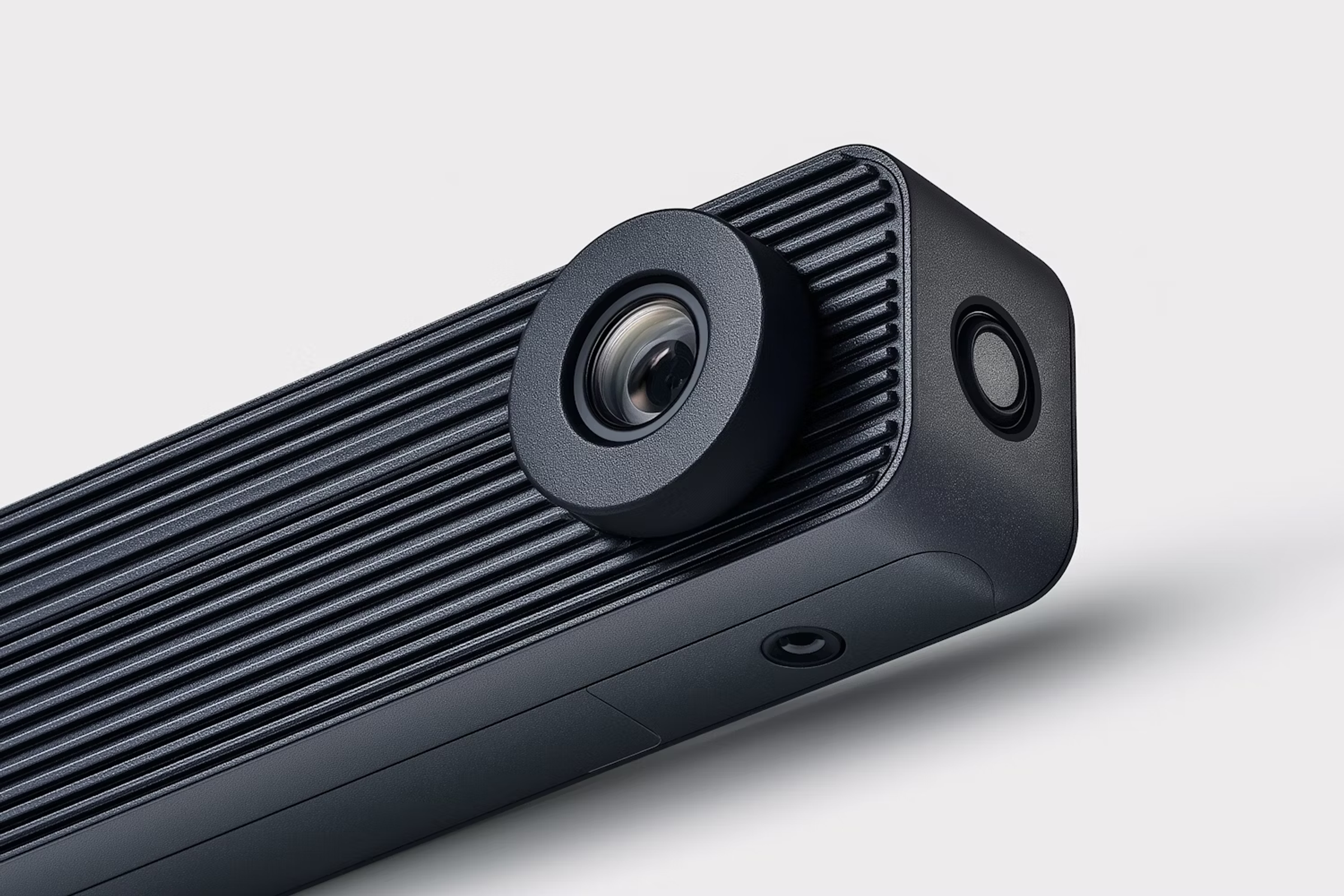 Close-up of a black camera module with a ribbed housing