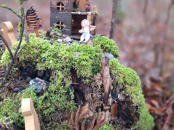 Wald mit geschmücktem Weihnachtbaum, Holzkerze, Holzkugeln und Krippe