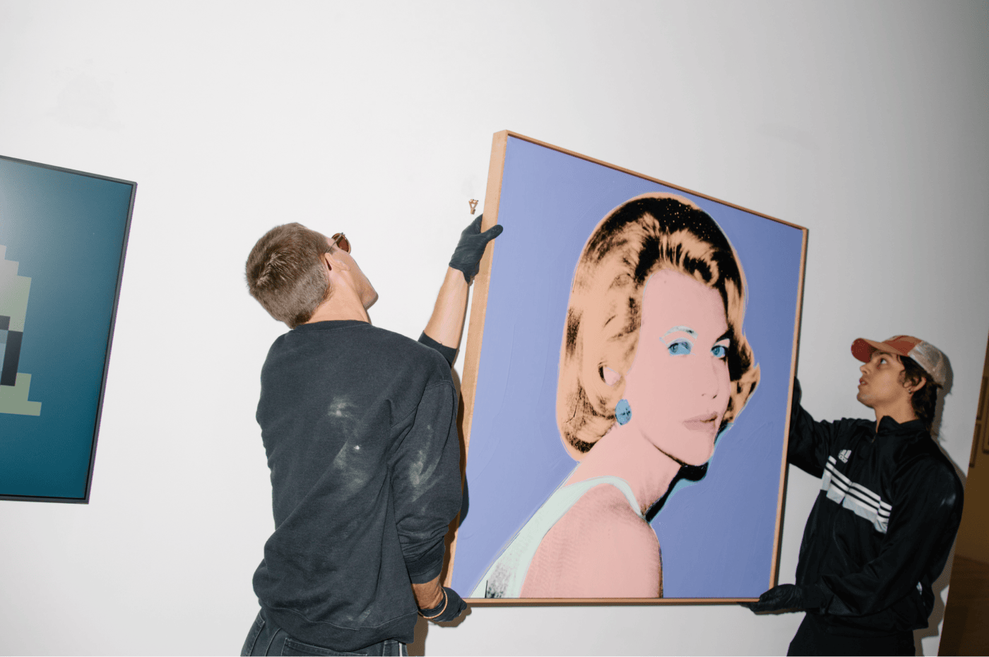 Two men hanging a painting