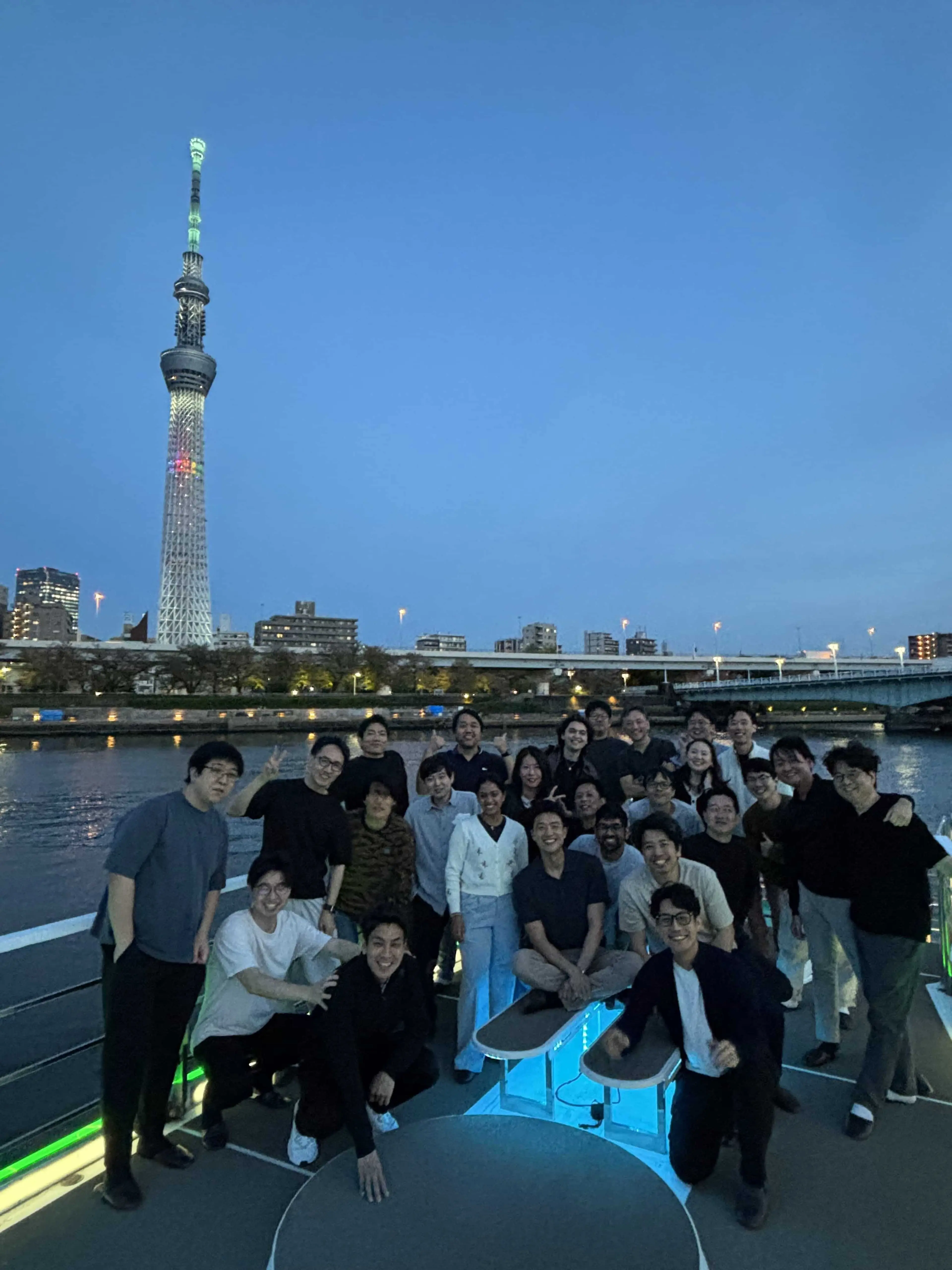 A group of people on a boat on a river, with a tower in the background