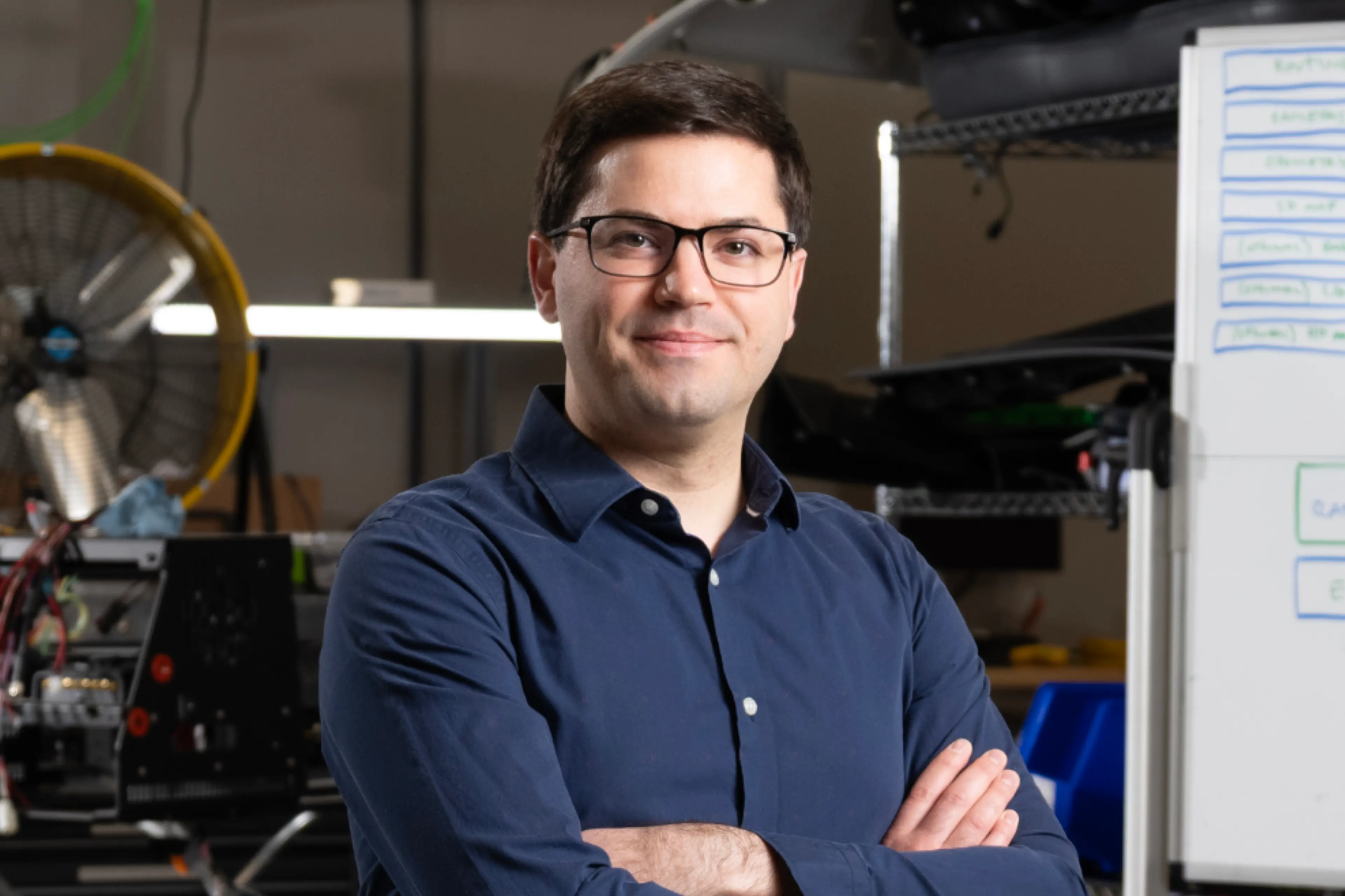 A man in a blue shirt and eyeglasses