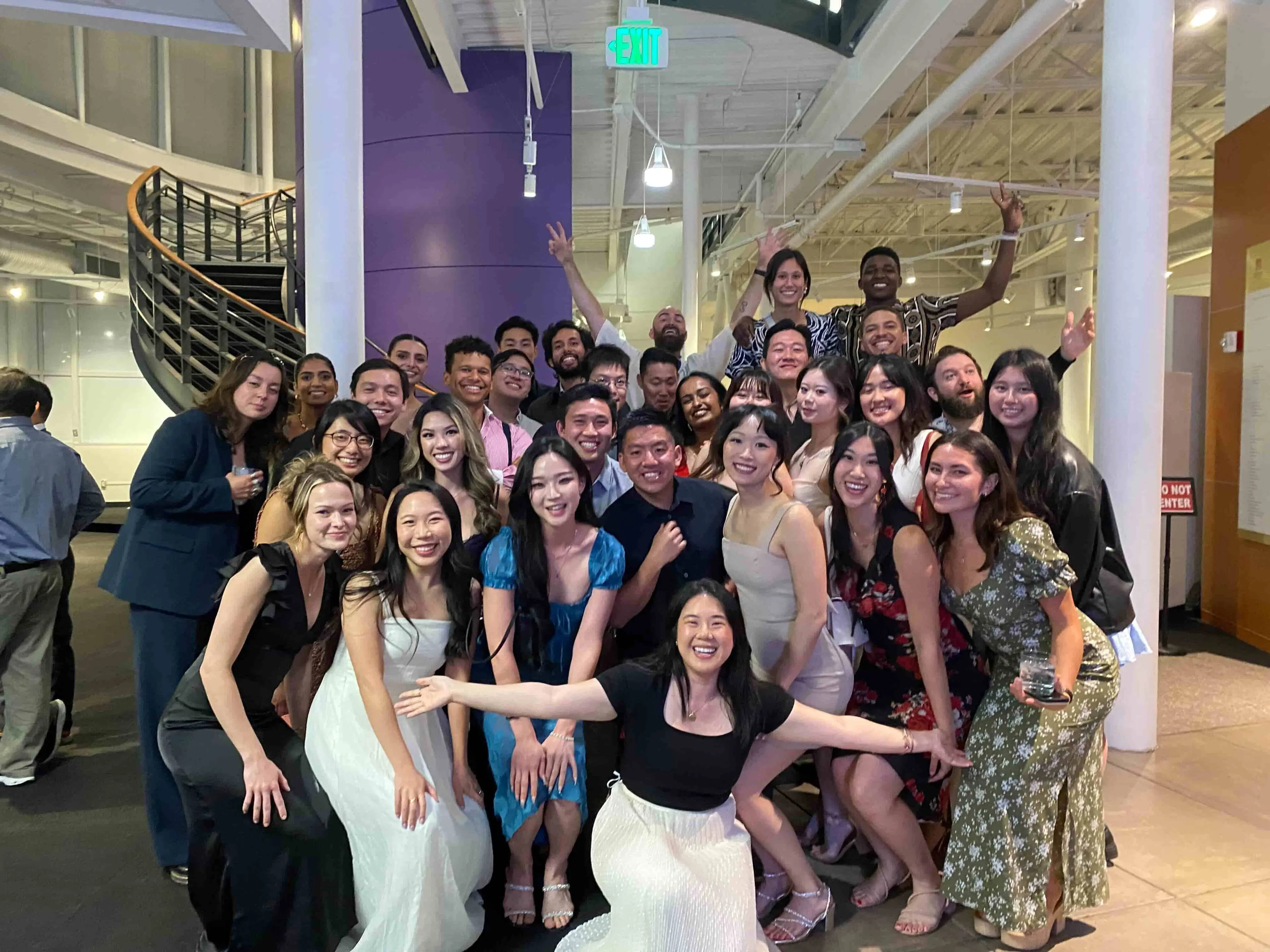 Group of about 30 people smiling and posing for a photo