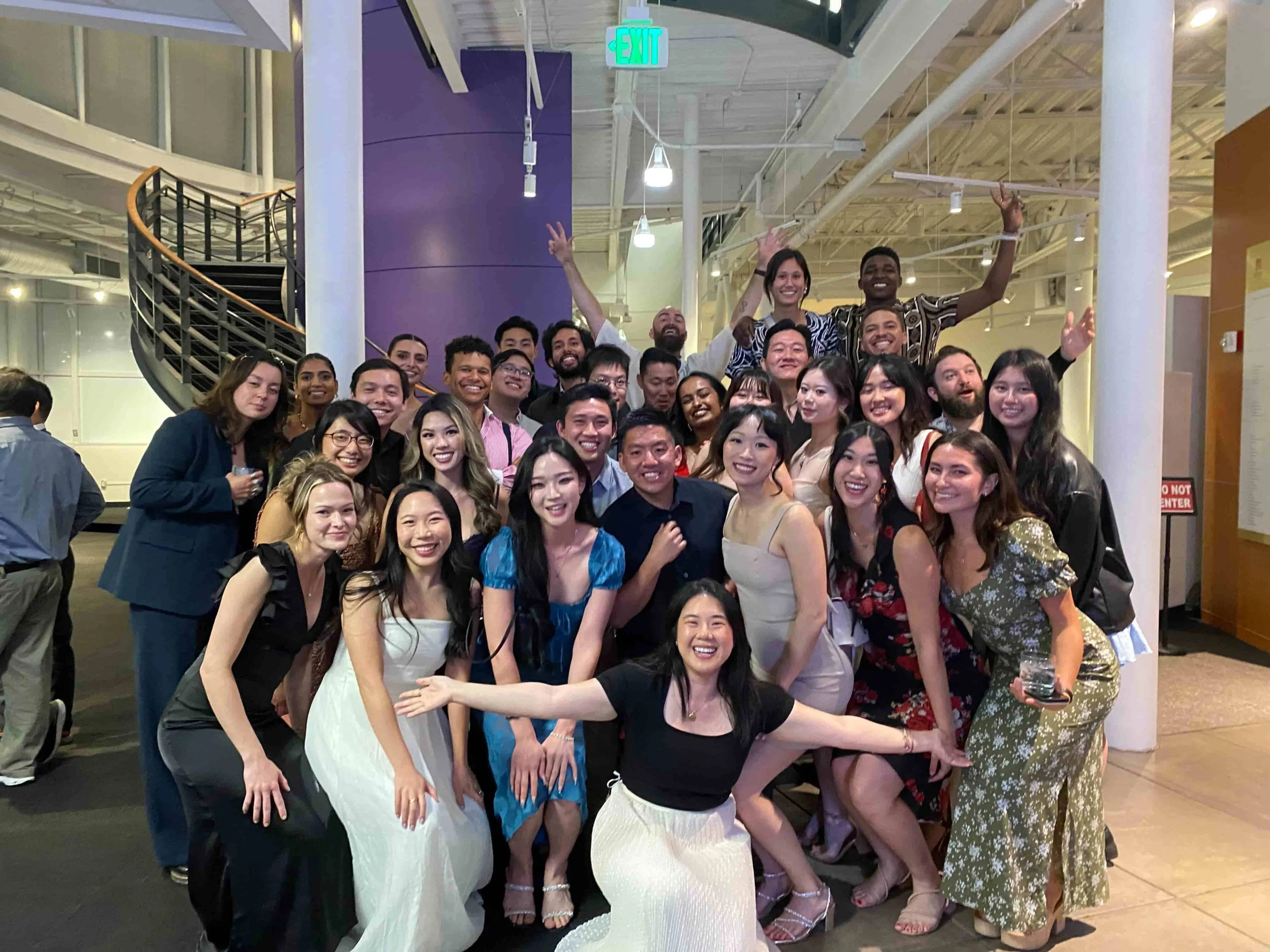 Group of about 30 people smiling and posing for a photo
