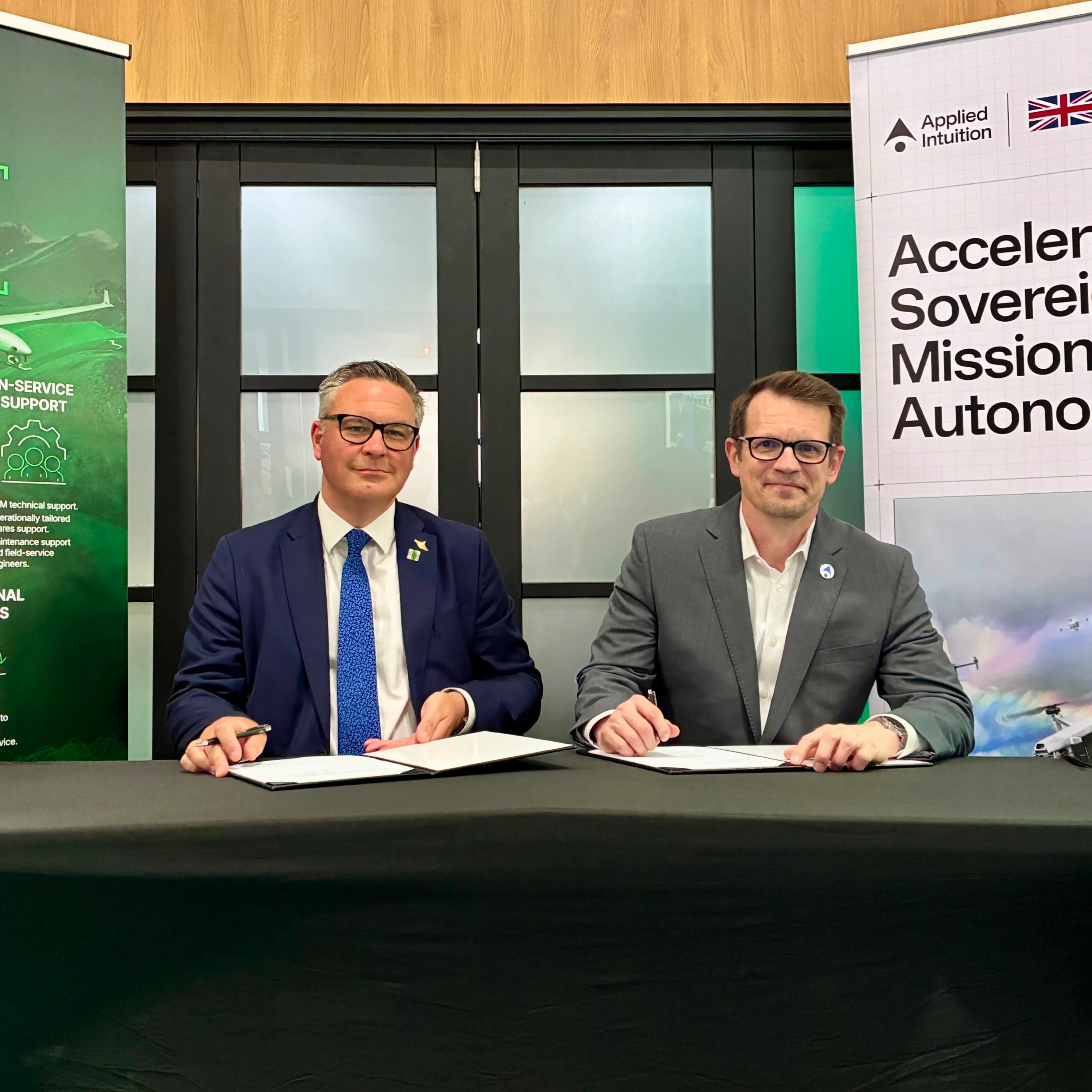 Executives shaking hands at a Callen-Lenz and Applied Intuition partnership signing.