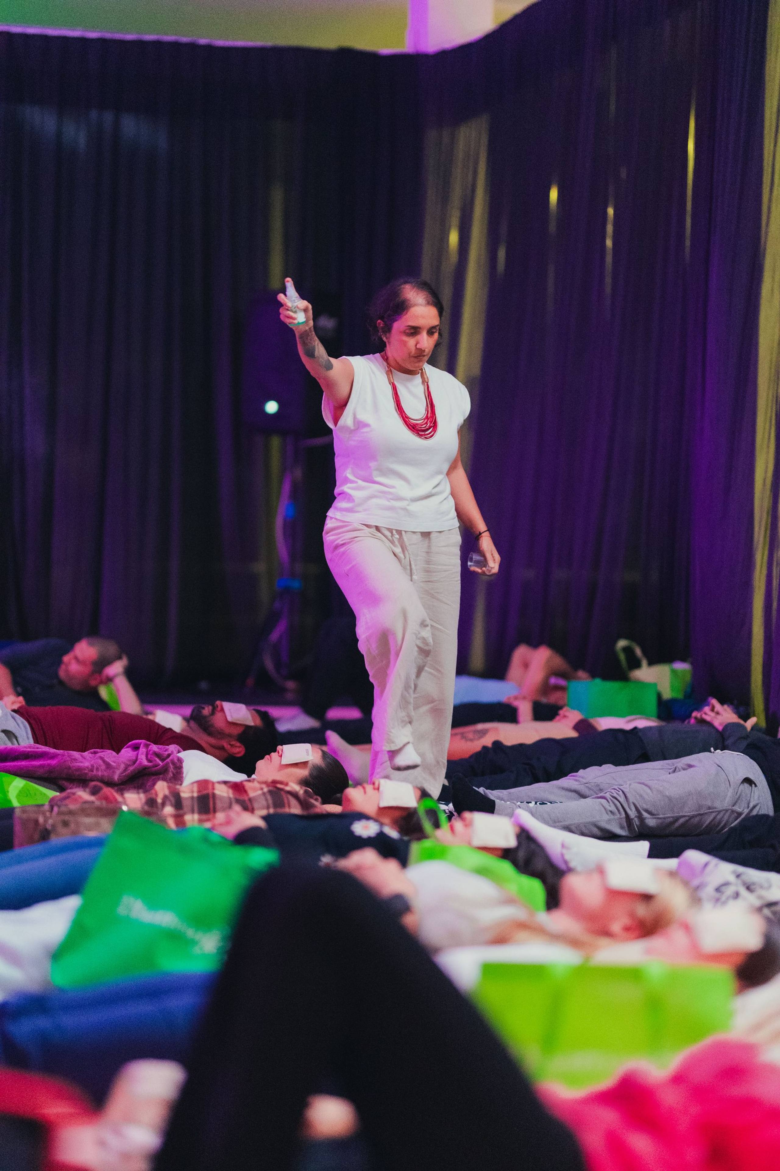 Facilitadora de pie entre participantes acostados