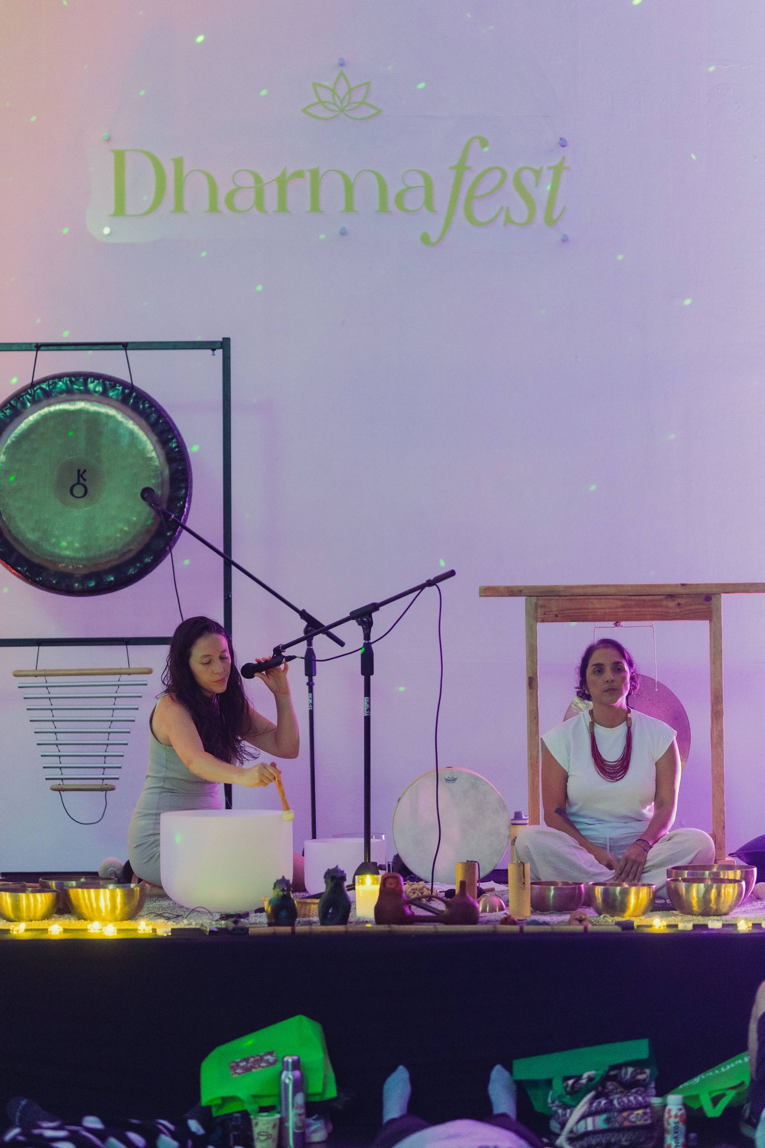 Facilitadora con gong y cuencos bajo luz violeta