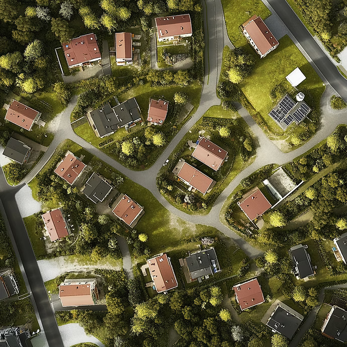 Flygbild över ett villaområde med rödmålade hus, vägar och grönska