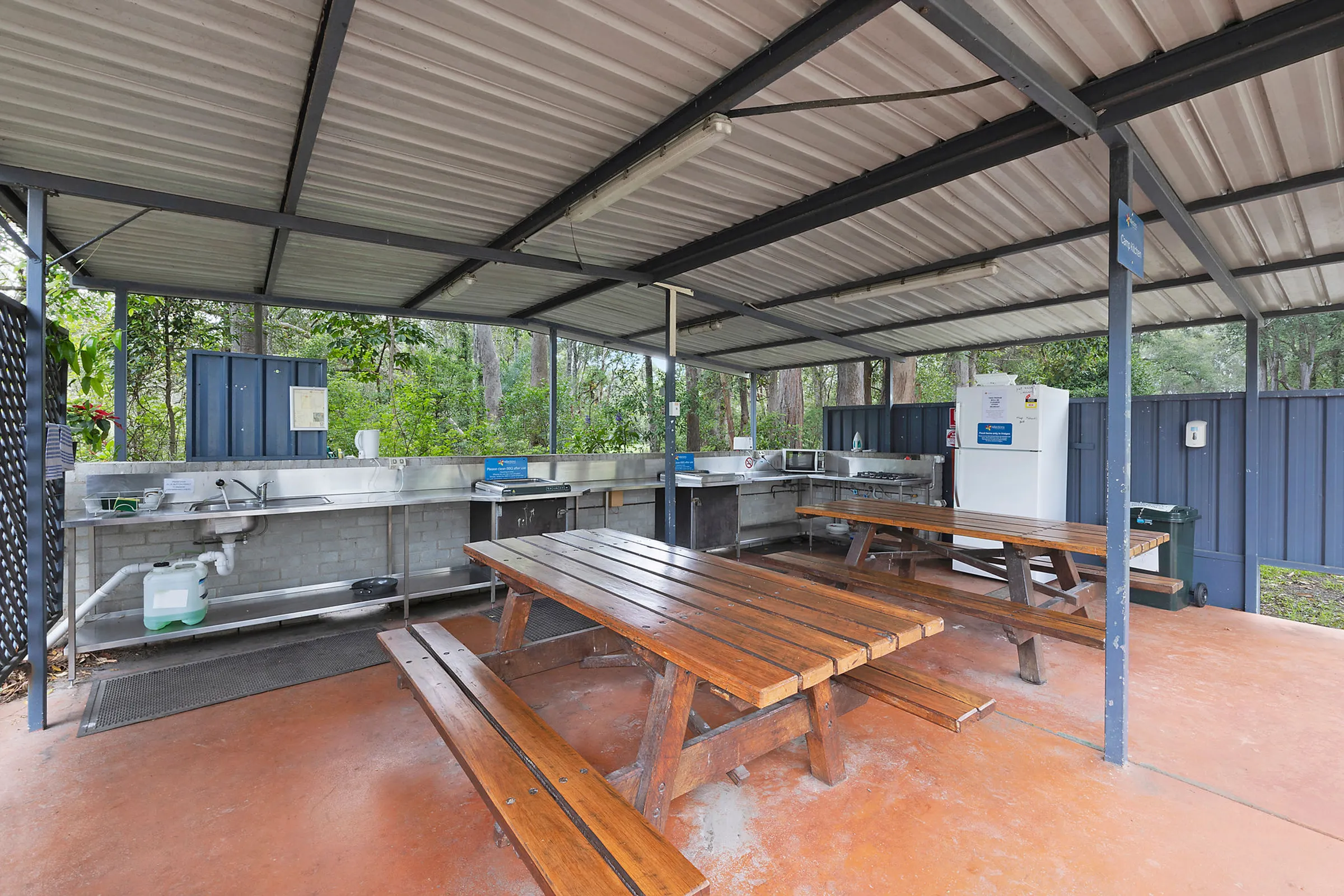 Reflections Holiday Park Coffs Harbour - BBQ cooking area within the camp kitchen featuring stainless steel benchtops and grills.