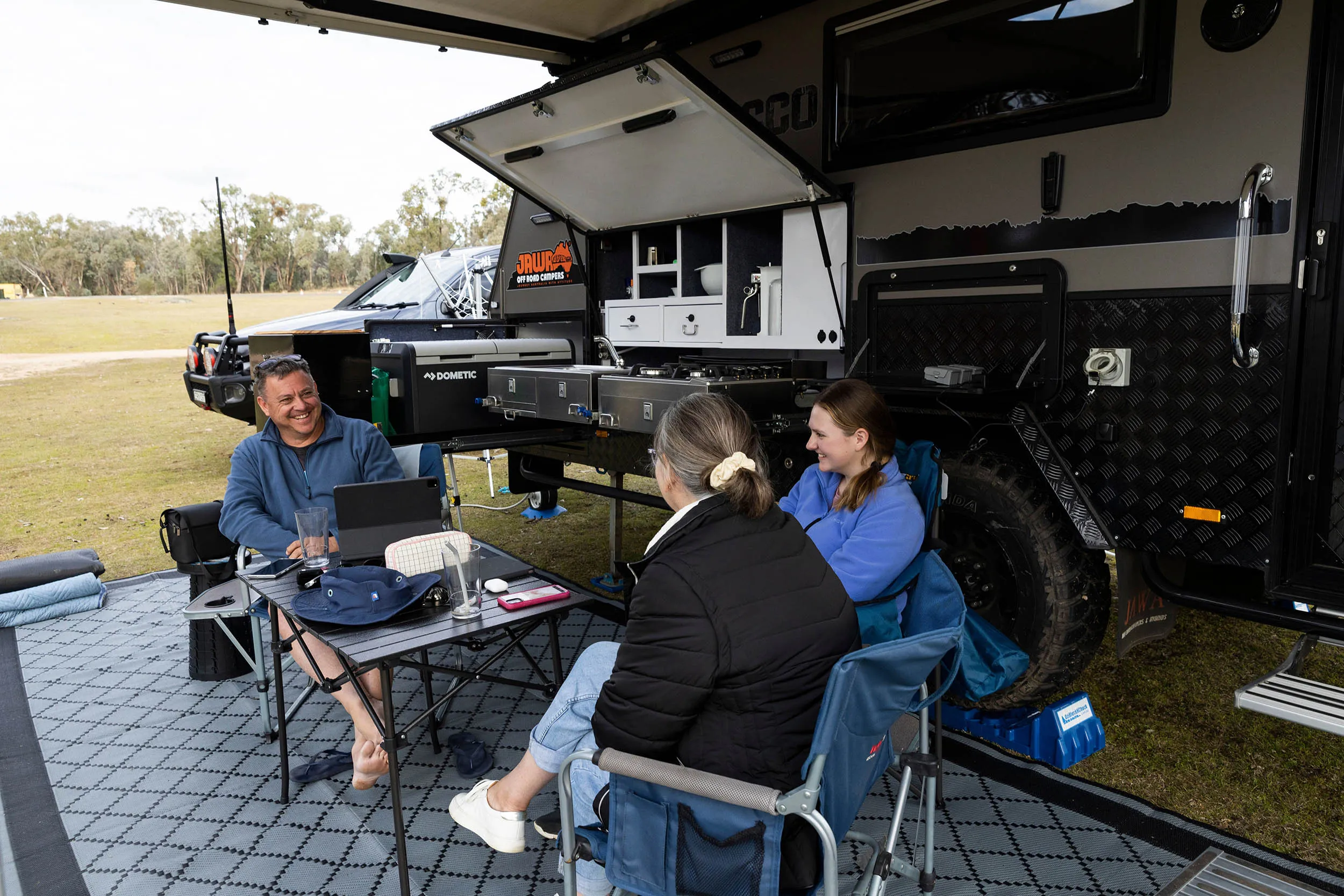 People sitting under their caravan shelter