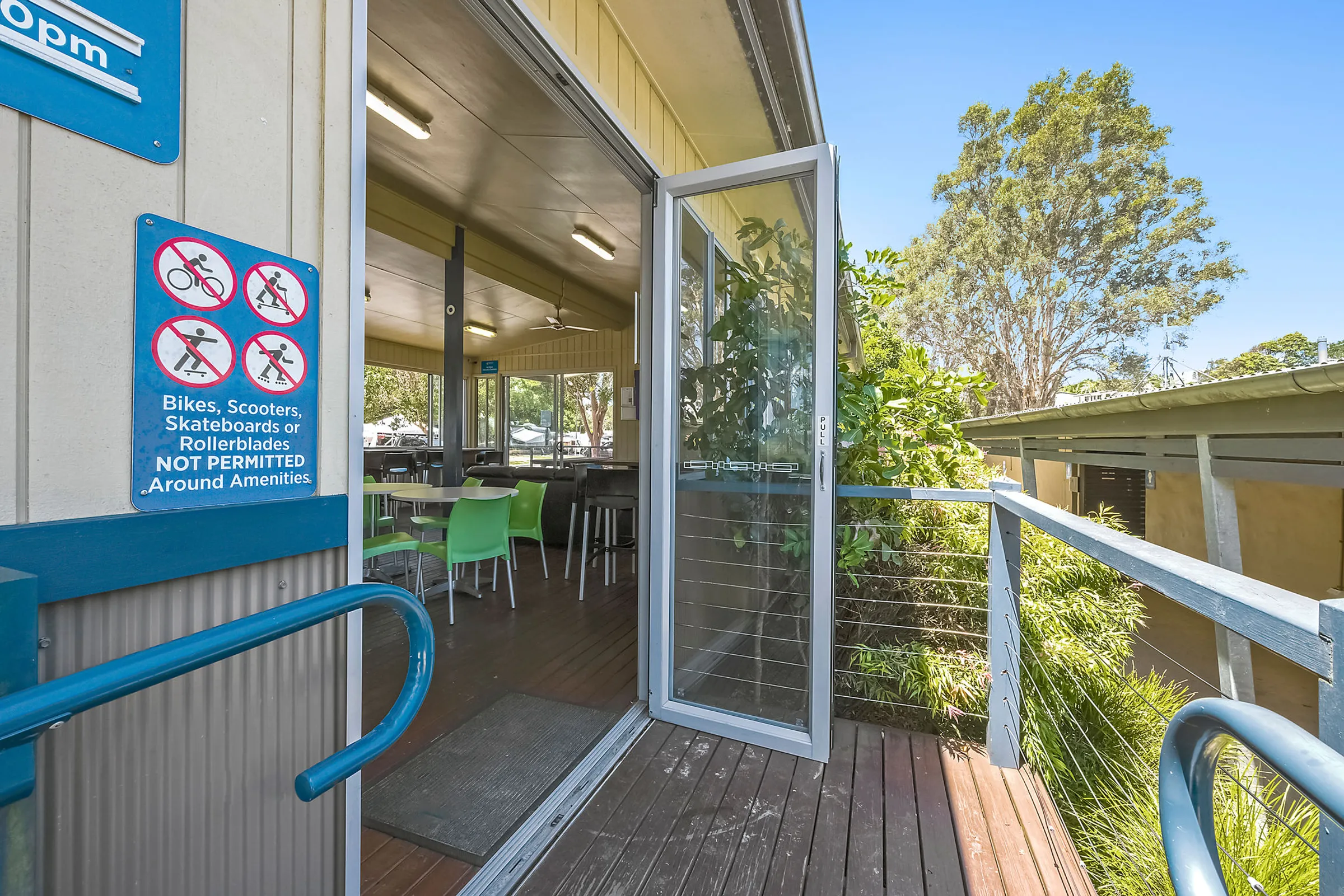 Dining area inside the camp kitchen at Reflections Scotts Head, featuring tables and chairs for guests to enjoy meals.