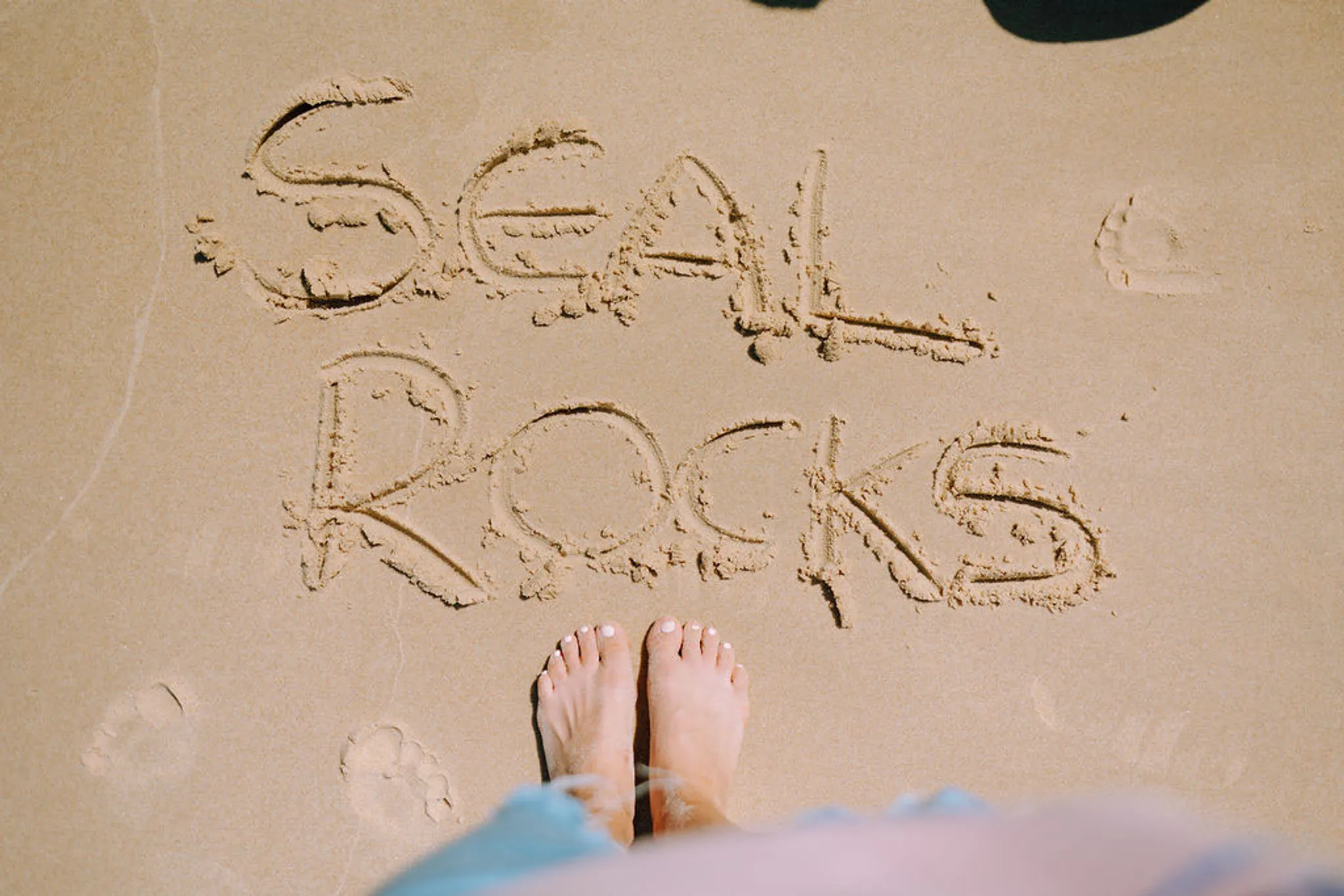 Seal Rocks written in the sand - Ethan Street