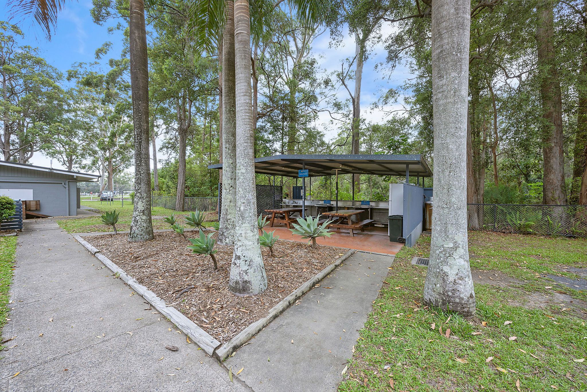 Reflections Holiday Park Coffs Harbour - Closer look at the camp kitchen, showing cooking appliances and seating arrangements.