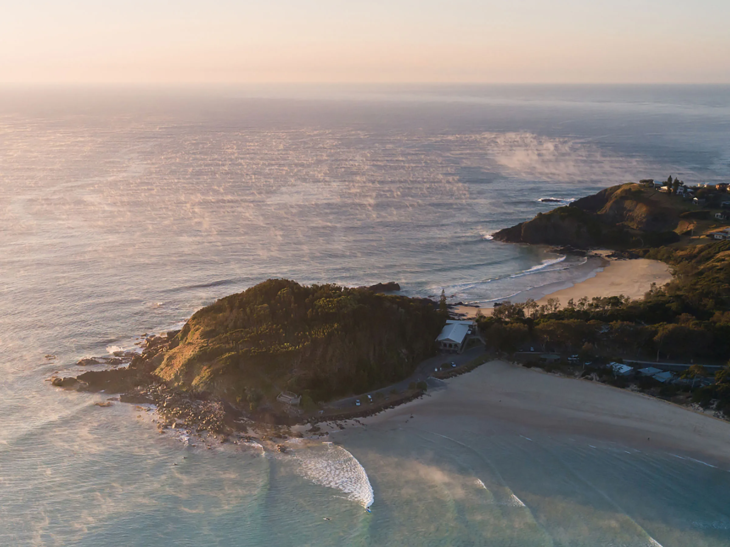 Reflections Scotts Head holiday and caravan park drone photo of Scotts Head Lookout and the holiday park on the beach