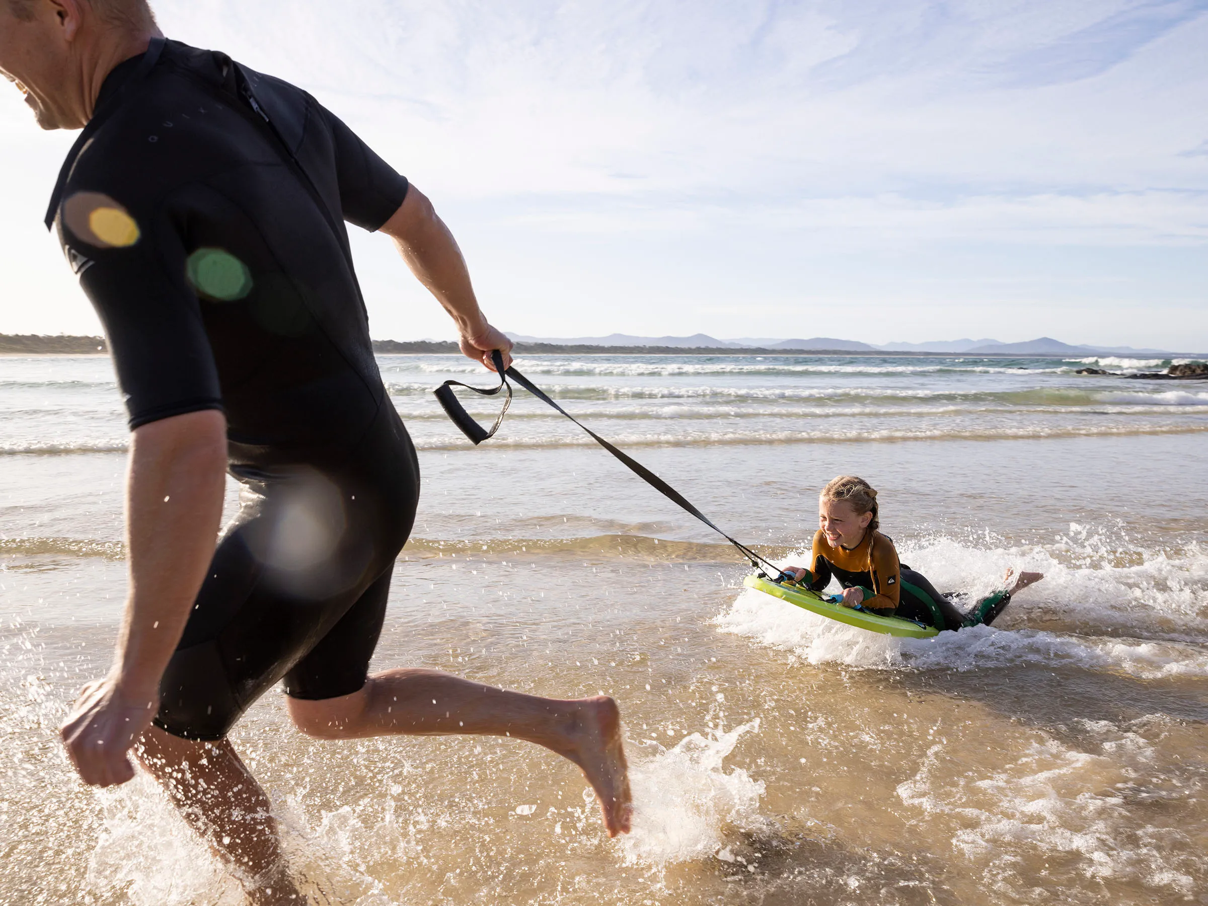 Reflections Scotts Head holiday and caravan park dad pulling son across water on boogie board