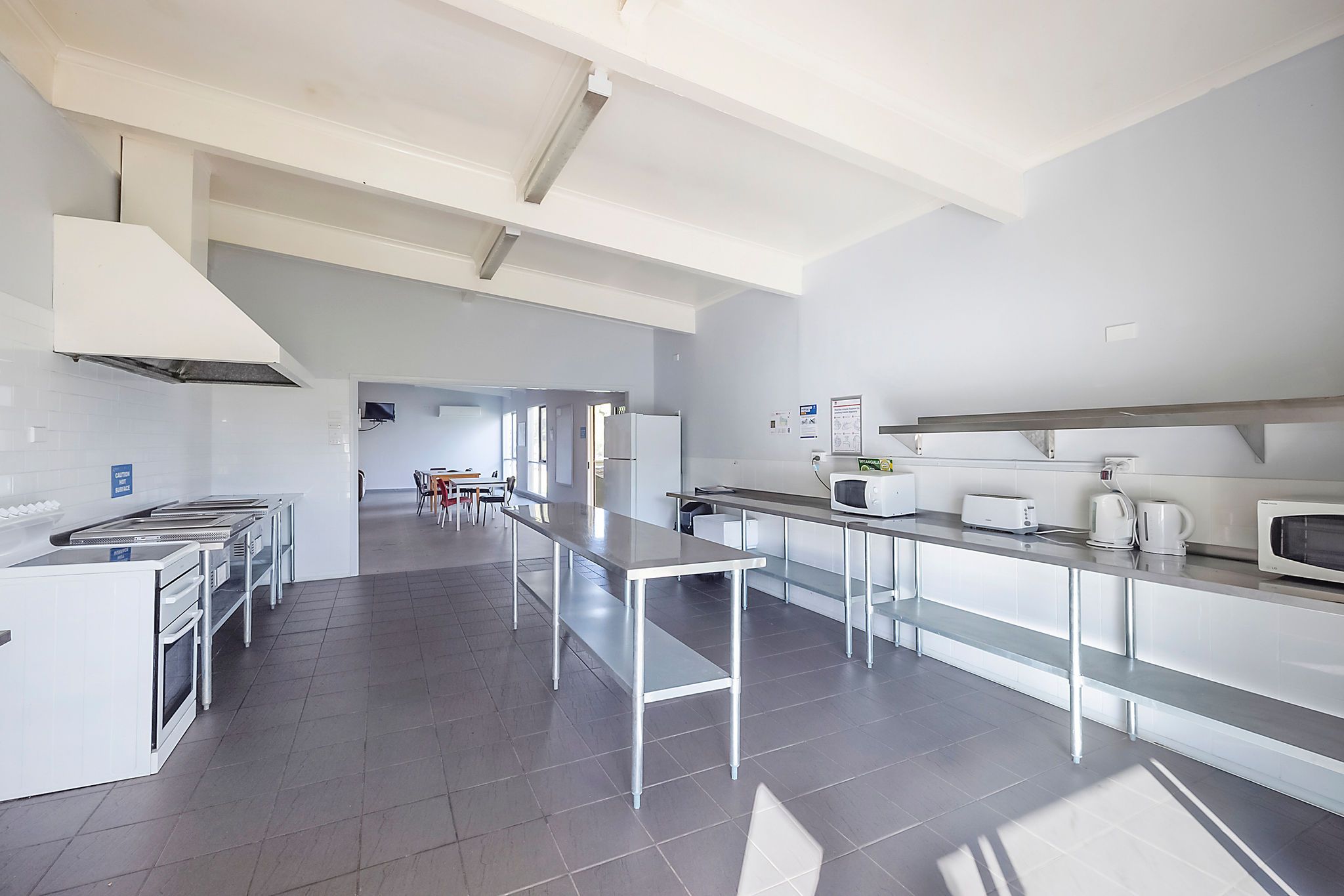 Spacious indoor kitchen at Reflections Wyangala Waters with ovens, microwaves, toasters, kettles, and stainless-steel benches