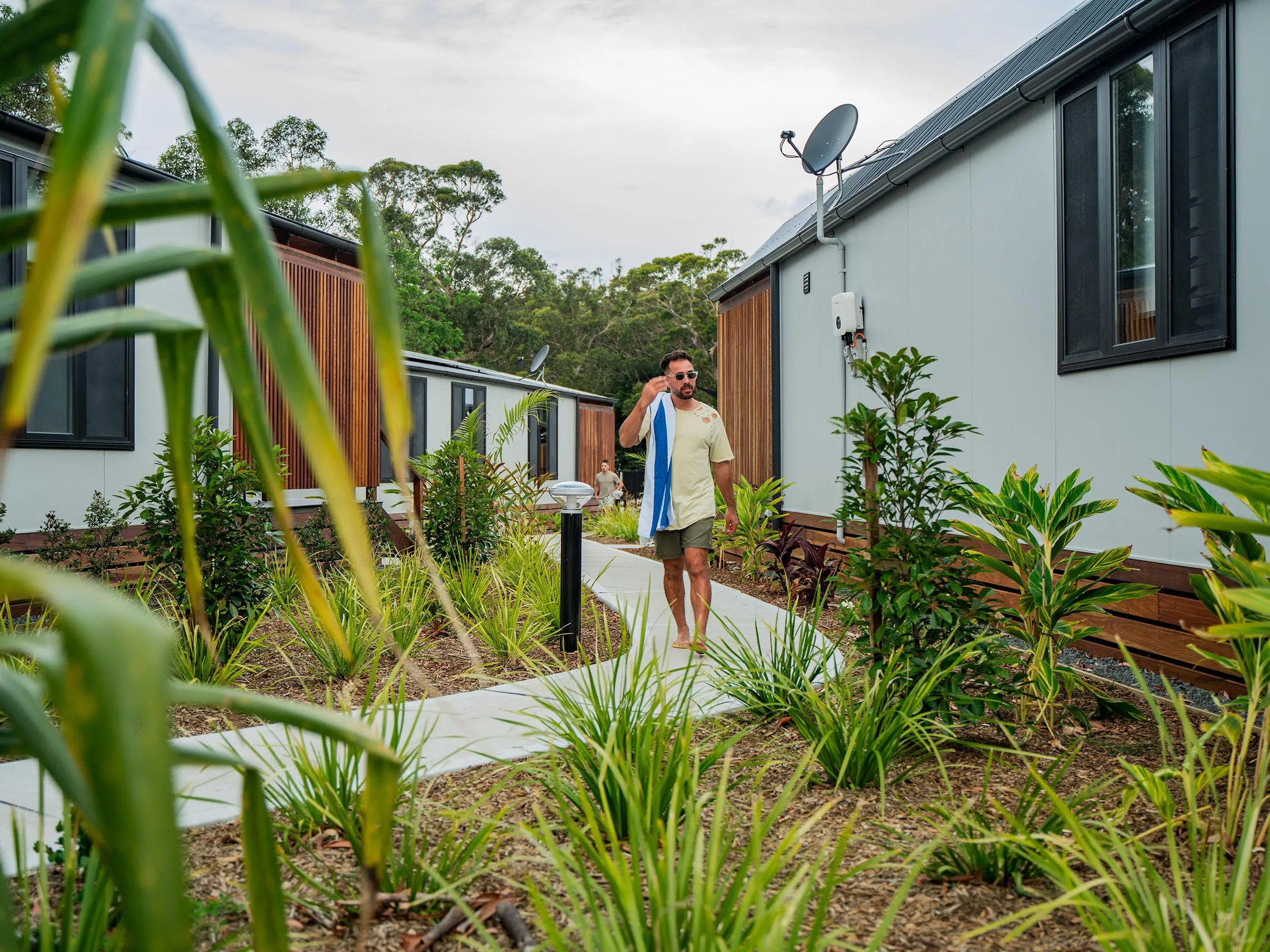 Reflections Holidays Jimmys Beach holiday & caravan park men walking to swimming pool through cabin precinct