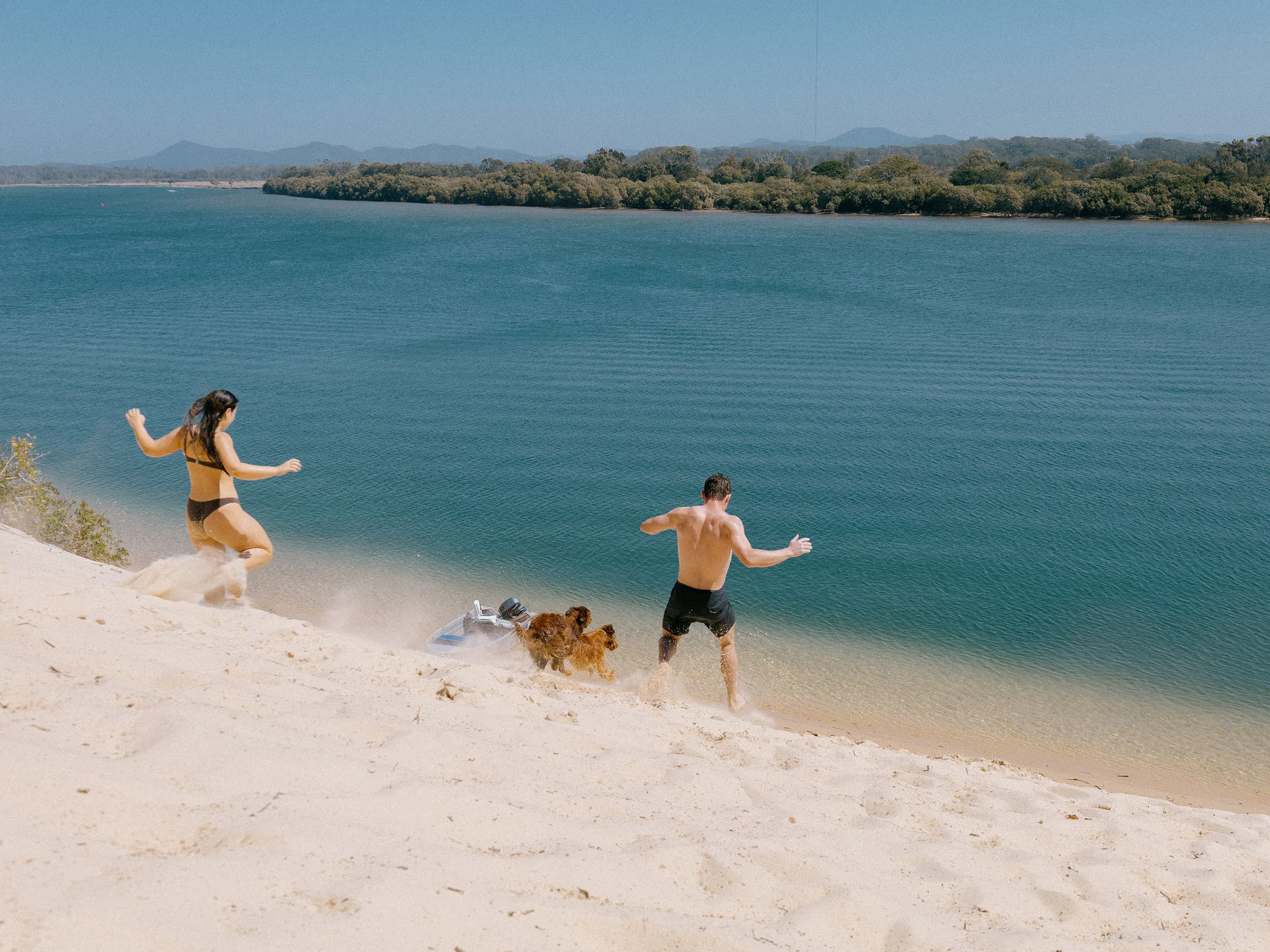 Reflections Mylestom holiday & caravan park North Beach Dunes two people running down with dog