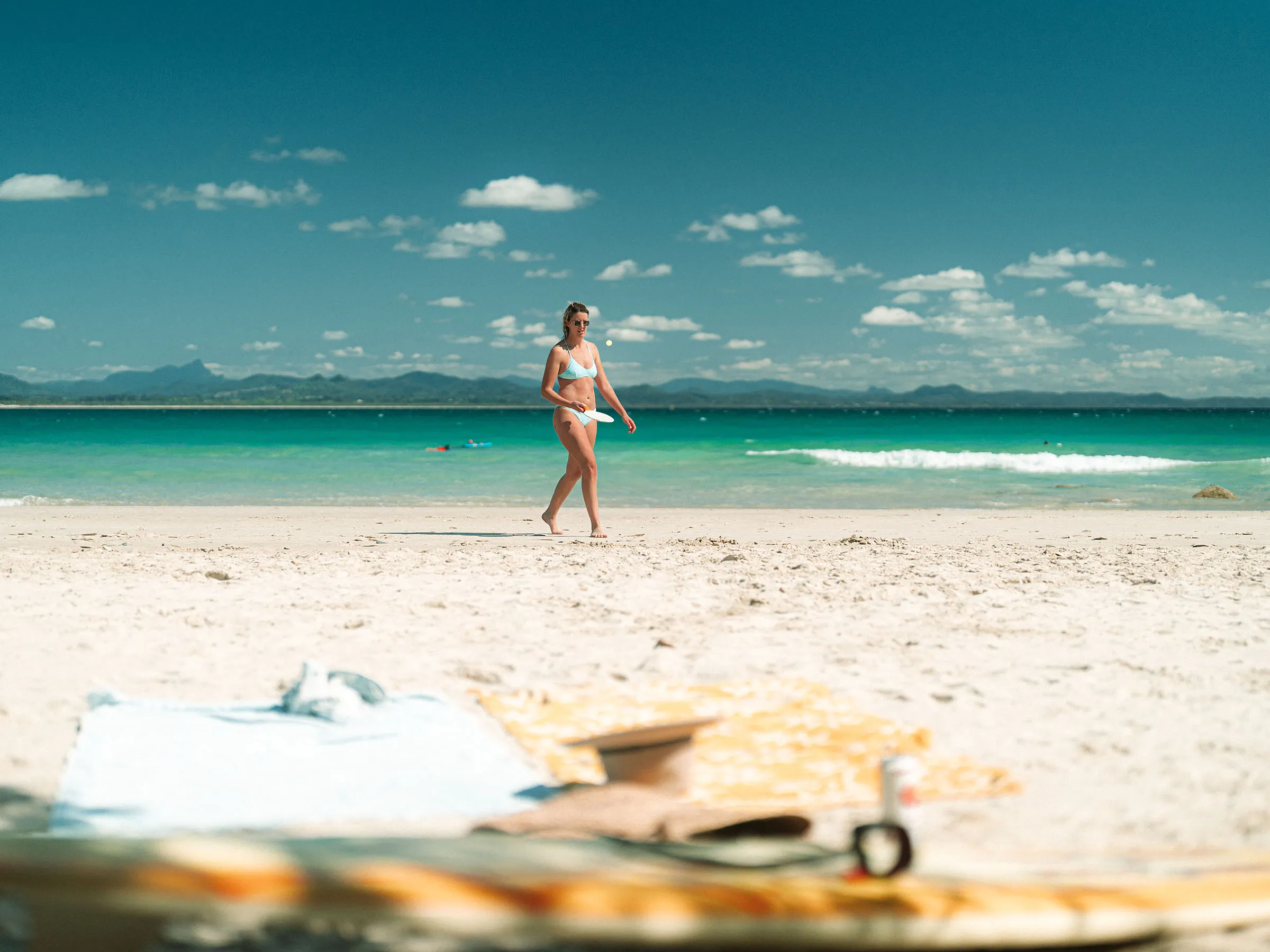 Reflections Byron Bay holiday & caravan park Clarkes Beach woman in swimmers walking on the beach