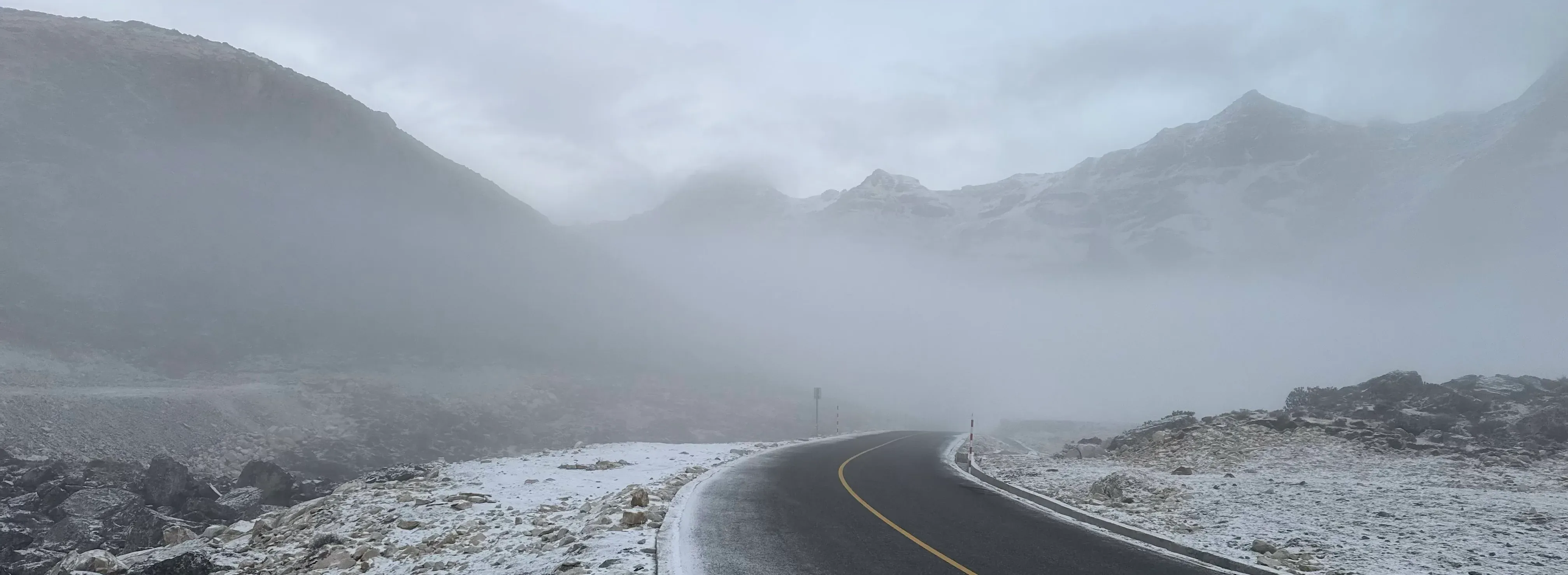 公路在风雪之后转入山谷，路外只剩灰白岩坡。